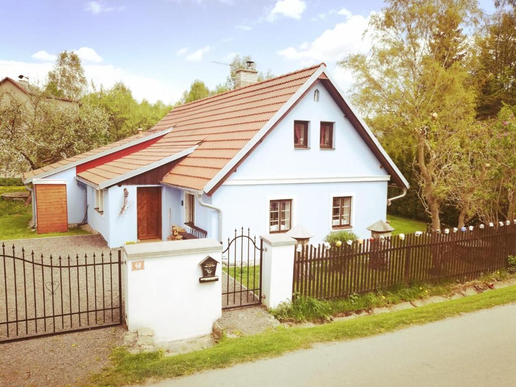 ein weißes Haus mit einem Zaun in der Unterkunft chalupa U Troubilů in Rváčov