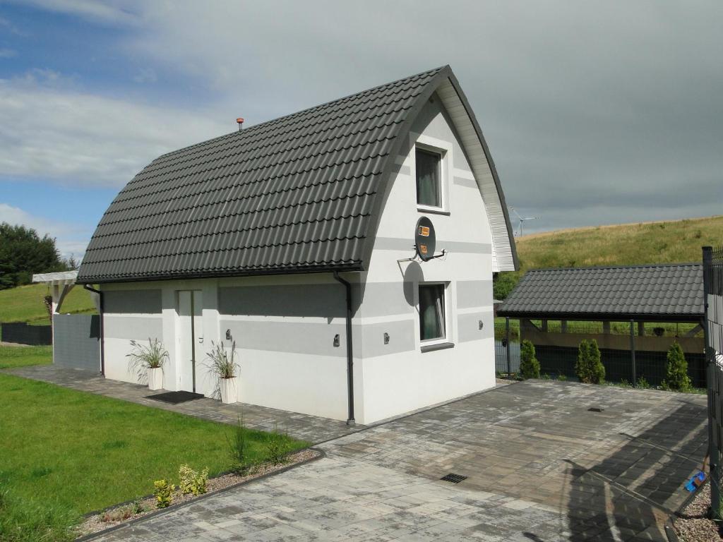 una casa blanca con techo negro en Cztery Pory Roku, en Gołdap