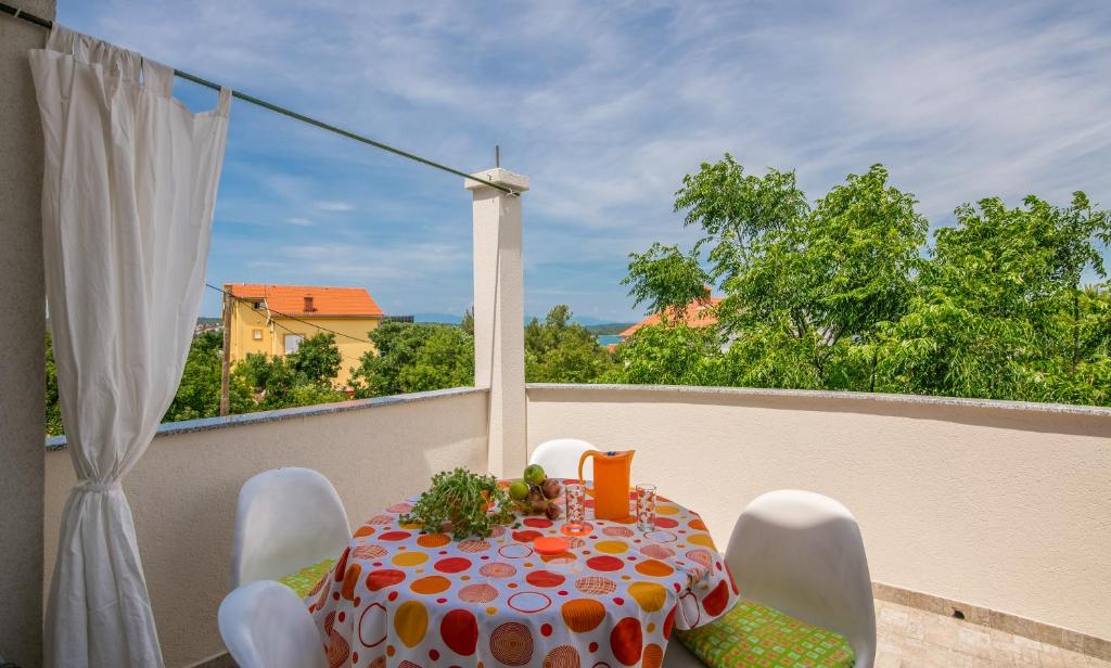 een tafel en stoelen op een balkon met uitzicht op de bomen bij Apartment Mira 2 in Klimno
