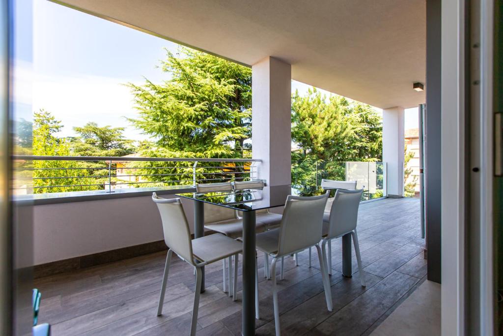 a glass table and chairs on the balcony of a house at L'Ospitale appartamento in Peschiera del Garda