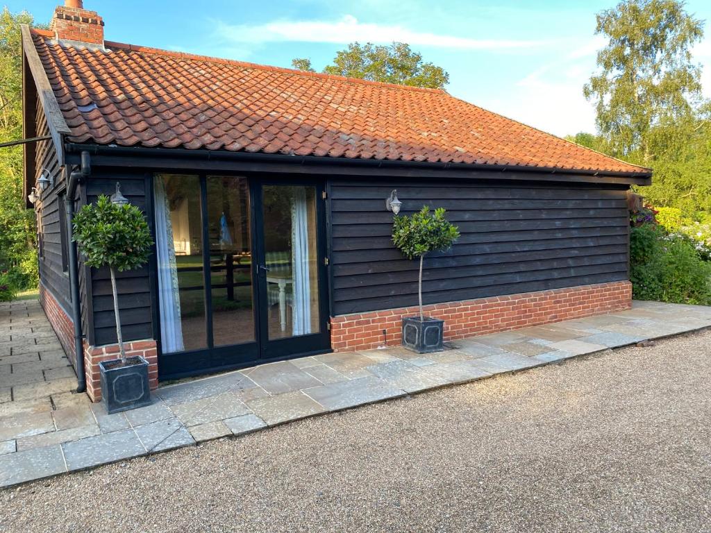 une petite maison avec un toit rouge dans l'établissement Brundish Suffolk Barn 2 Bed Idyllic 6 acres, à Wilby