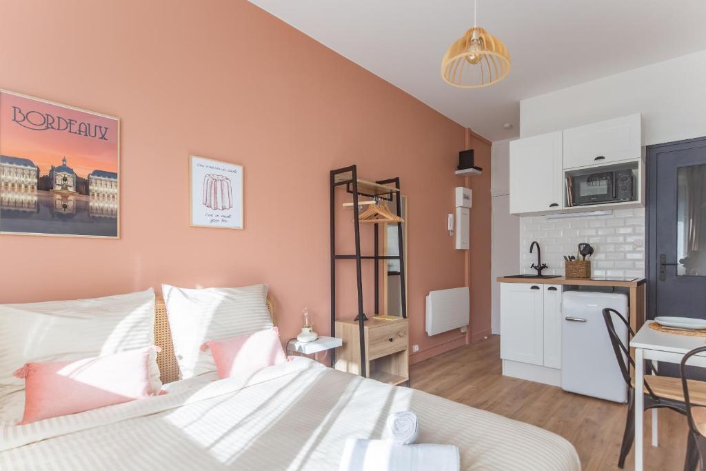 um quarto com uma cama e uma pequena cozinha em Les Studios du Parc Bordelais - Le Canelé em Le Bouscat