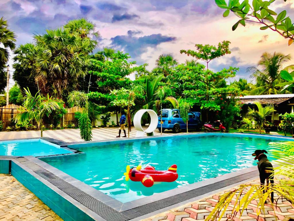 uma piscina com um brinquedo vermelho na água em Trinco Star Cabana em Trincomalee