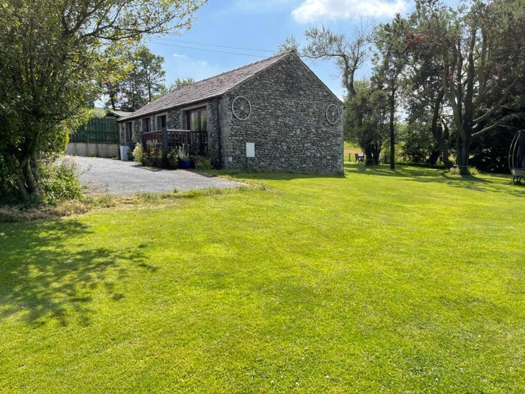 uma casa de pedra num campo de relva verde em Lake District cottage in 1 acre gardens off M6 em Penrith