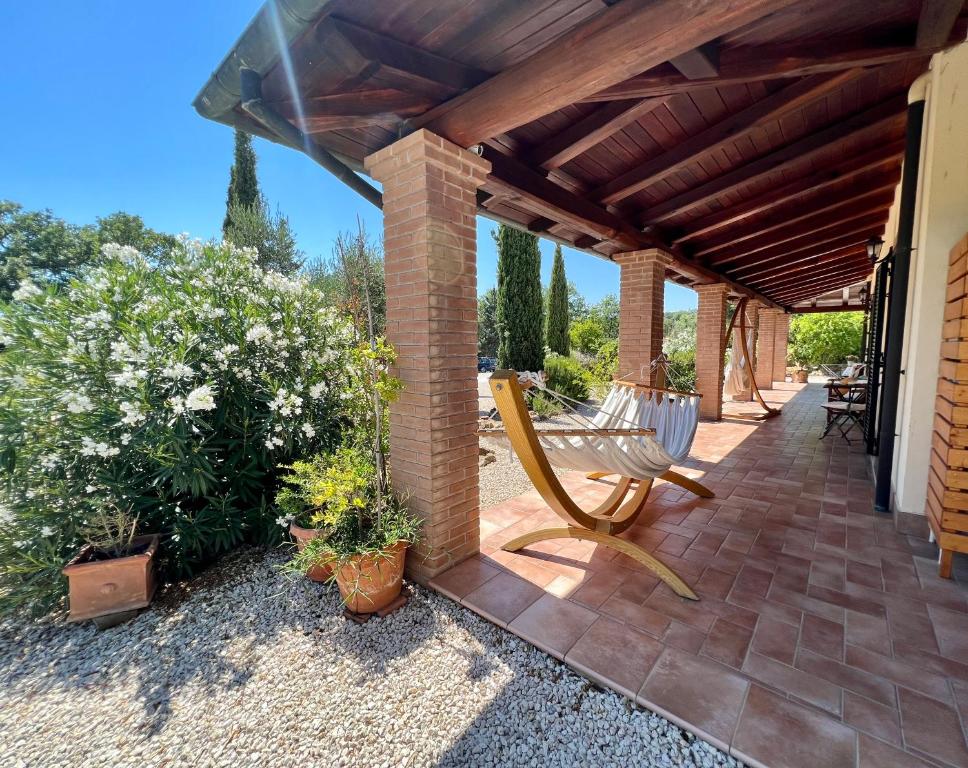 a patio with a bench and some plants at Casale Terre Rosse in Saturnia