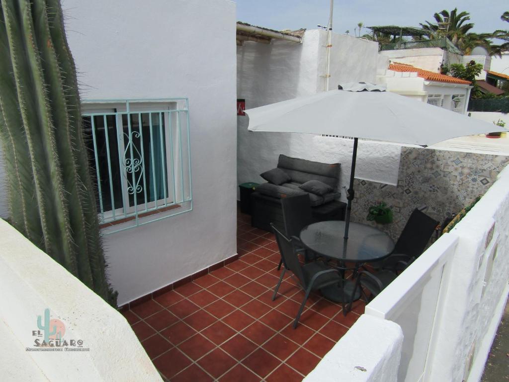 a patio with a table and an umbrella at El Saguaro in Arona