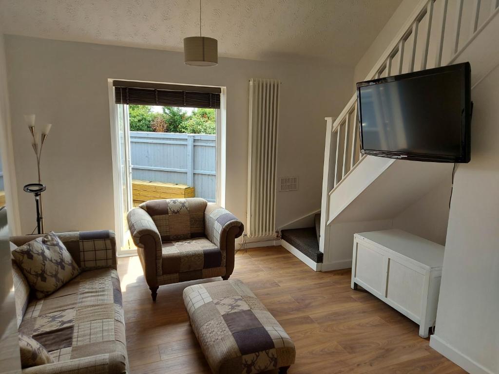 a living room with a couch and a tv at 1 Bedroom House with Garden and off road private parking in Peterborough