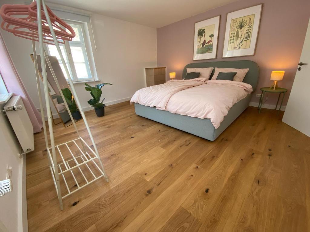 1 dormitorio con 1 cama y suelo de madera en SCHLOSS & ALTSTADT - Modern & Stylish für 6 Küche, en Dachau