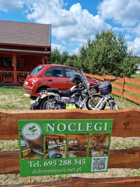 a motorcycle parked in front of a sign on a fence at Dobre Miejsce na Roztoczu in Huta Różaniecka