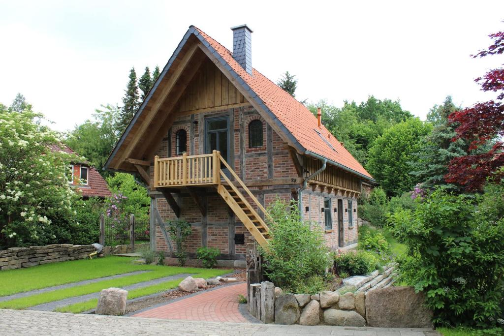a large wooden house with a porch and a balcony at Haus am Fischendorfer Bach in Bad Fallingbostel