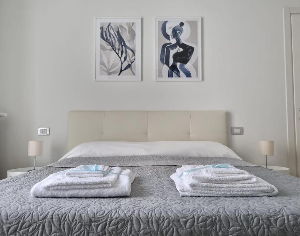 a bedroom with a bed with towels on it at Claro Apartments - Prampolini 12 in Milan