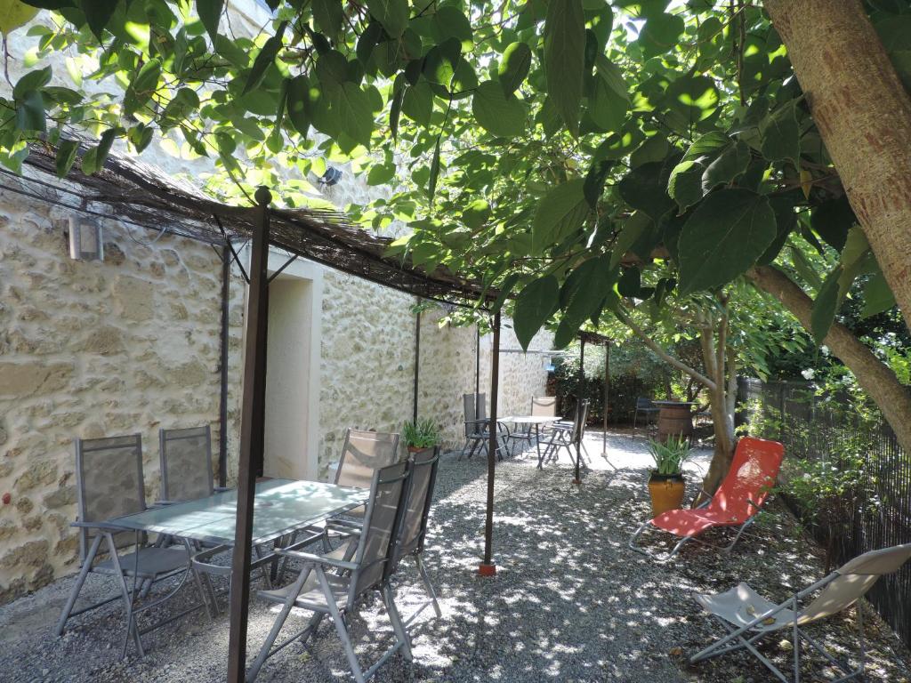 Sallèles-dʼAudeにあるGîtes Le "Val-Léa"の木の下にテーブルと椅子のあるパティオ