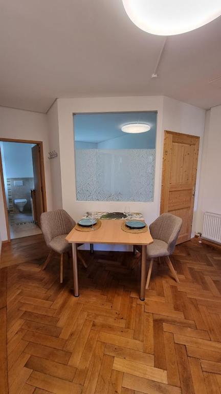 einen Tisch und Stühle in einem Zimmer mit Holzboden in der Unterkunft Auszeit im Bad Diezlings in Hörbranz
