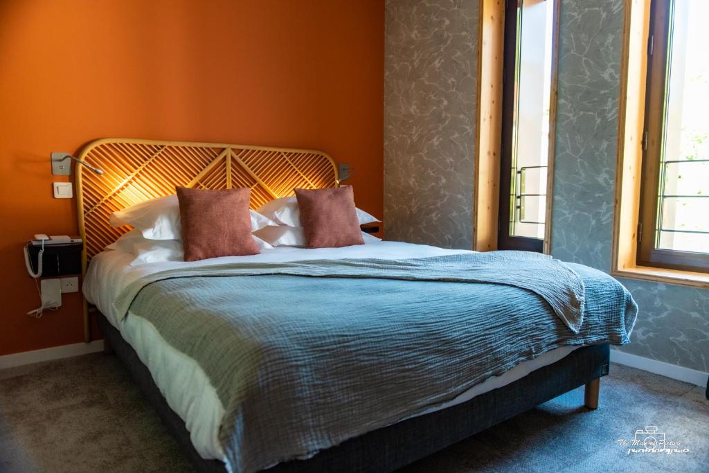 1 dormitorio con 1 cama grande y paredes de color naranja en Logis Hôtel Altitude et Spa Pierre-Percée, en Pierre-Percée