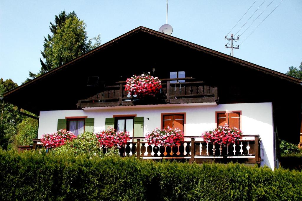 a white house with flowers on a balcony at Apartment Utschneider-Holzer in Bad Bayersoien