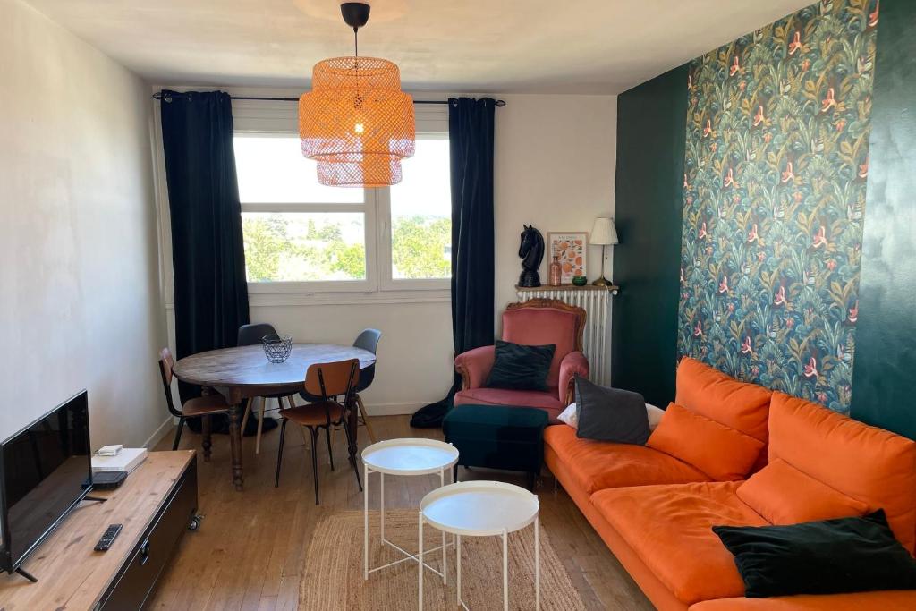 a living room with an orange couch and a table at Les Lys Lumineux Élégant Raffiné Tours in Tours