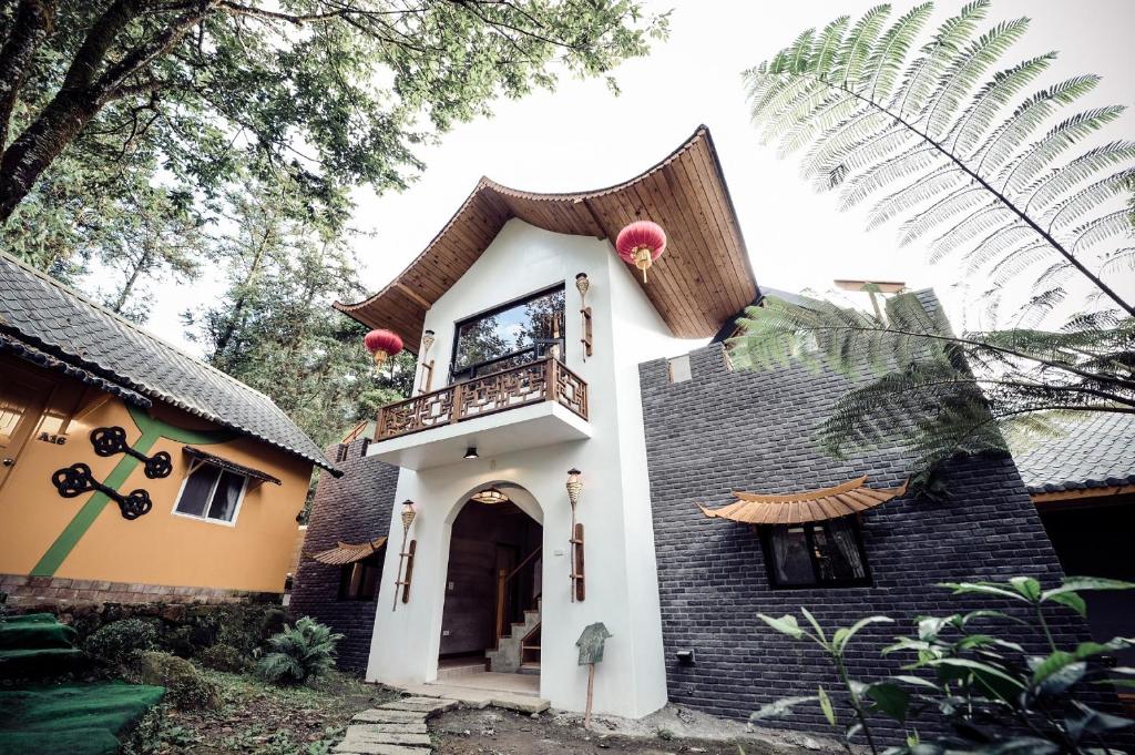 a house with a gambrel roof and a balcony at Tingtau Villa in Lugu Lake