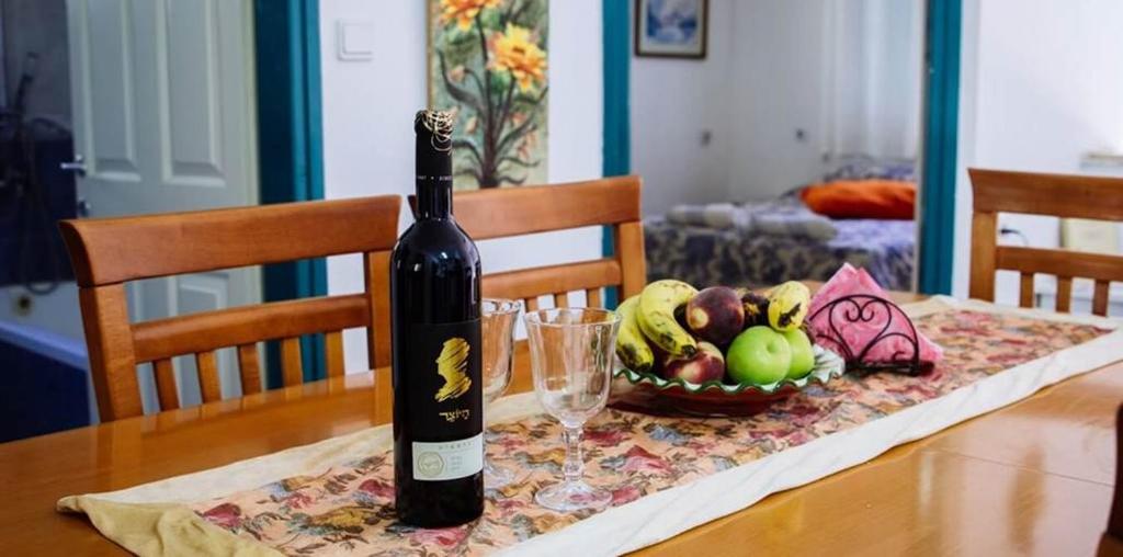 a bottle of wine sitting on a table with a bowl of fruit at חלום בגורן -יחידת אירוח in Metulla