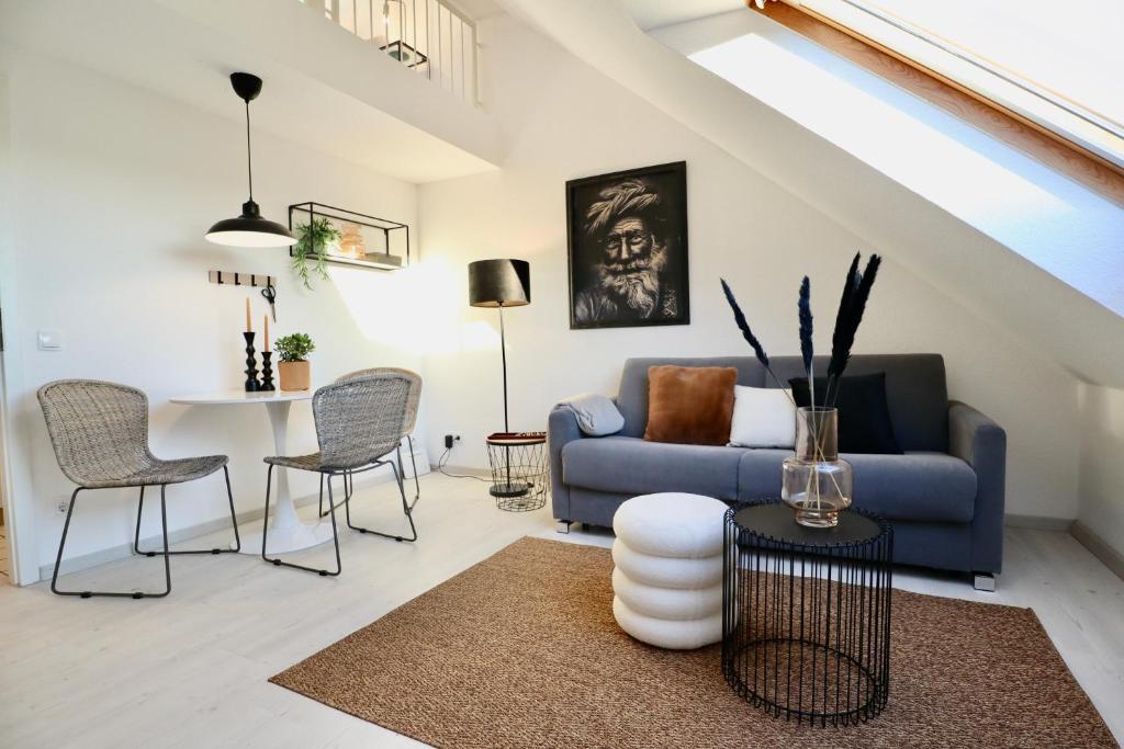 a living room with a blue couch and a table at GALLERY APARTMENT: MAISONETTE + FREE PARKING + NETFLIX in Essen