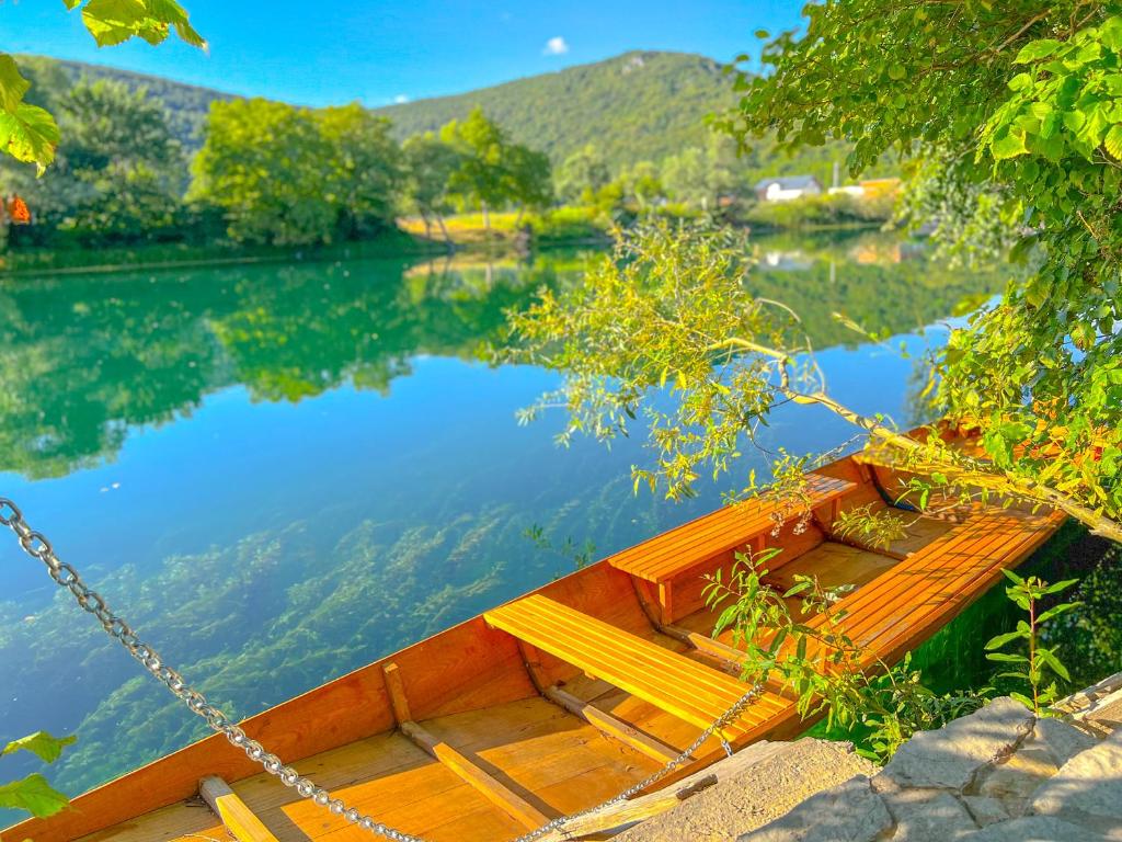 a wooden boat chained to the side of a lake at Daman Villa in Bihać