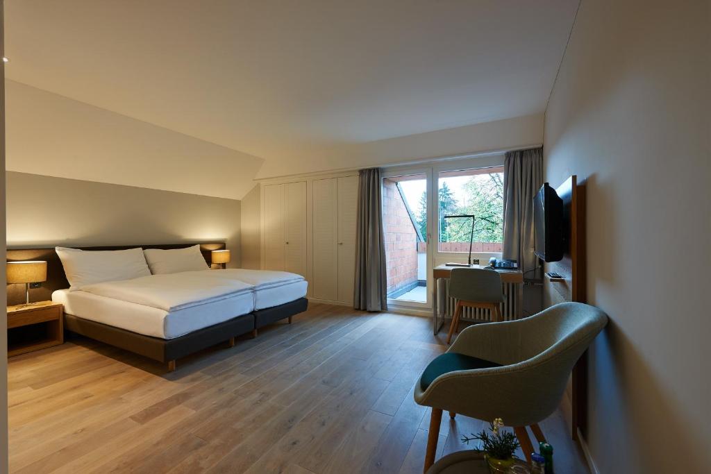 a hotel room with a bed and a television at Parkhotel Wallberg in Volketswil