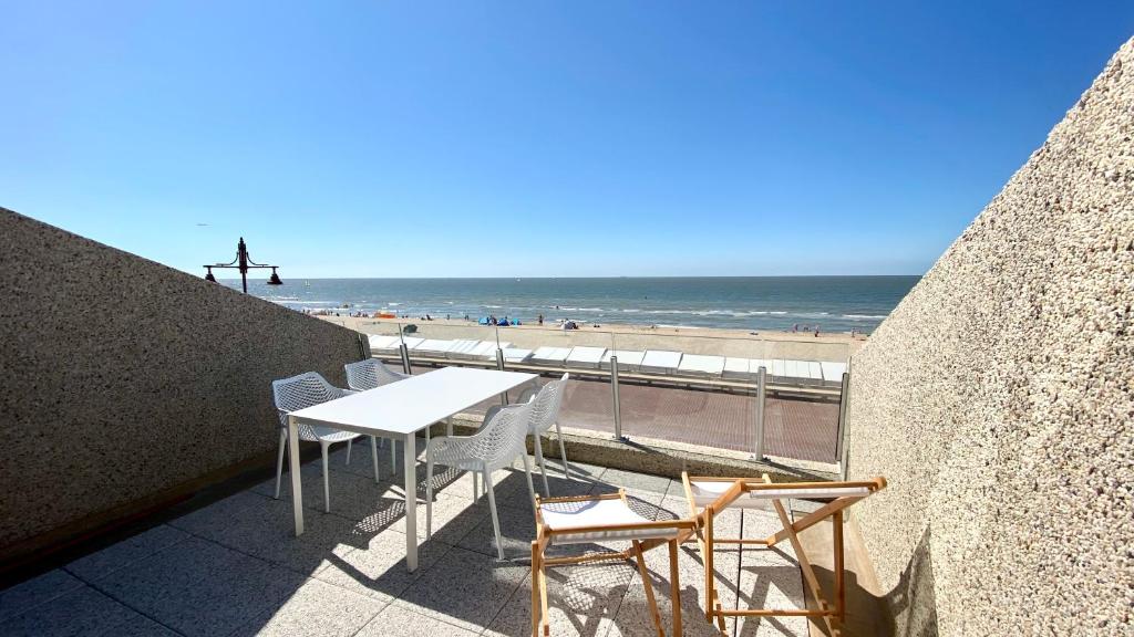 - Balcón con mesa y sillas y vistas a la playa en DeHaanStudio, en De Haan