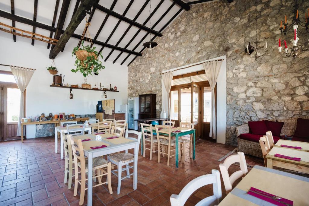 a restaurant with tables and chairs and a stone wall at Agriturismo Ristorante Monte Argentario in Monte Argentario
