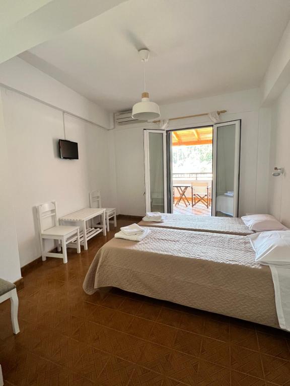 a large bedroom with a large bed and a window at Vasiliki apartments in Lákka