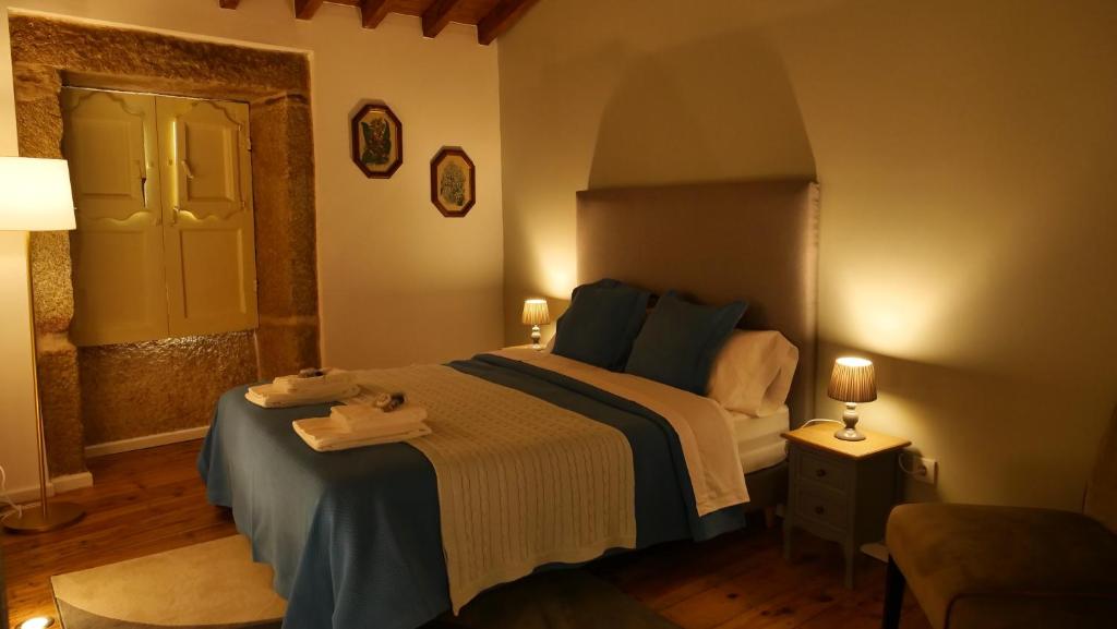 a bedroom with a bed with a blue and white blanket at Casarupa do Viriato in Torre de Moncorvo