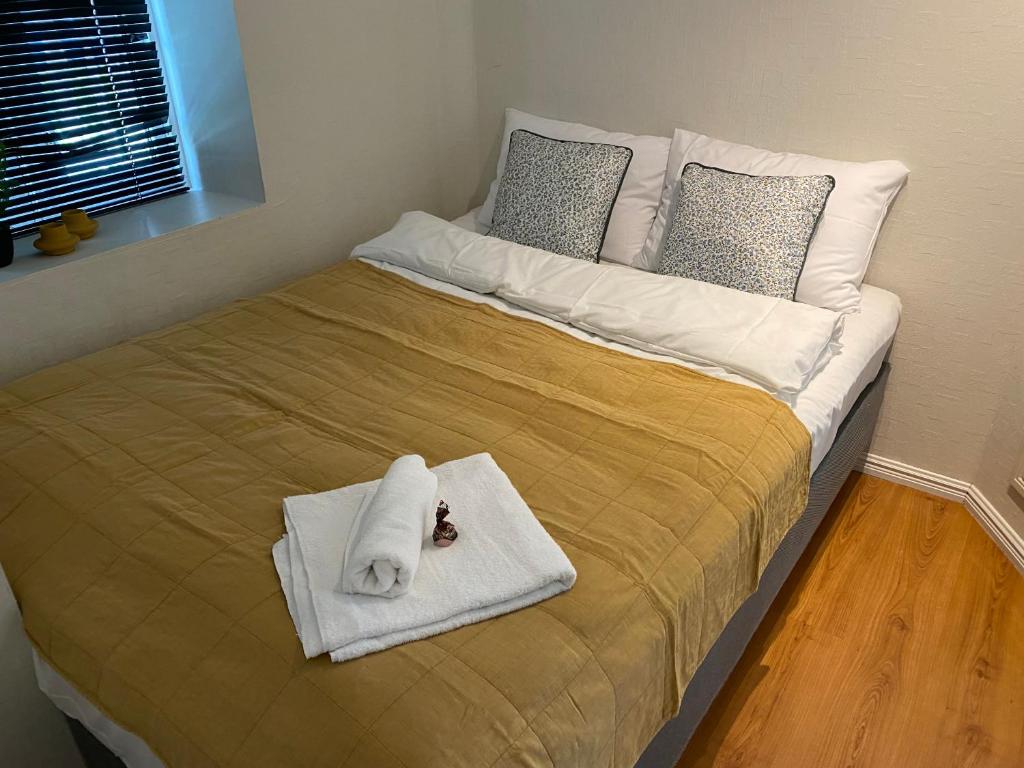 a bed with towels and pillows on top of it at Central bus station apartment, wifi, tv in Narvik