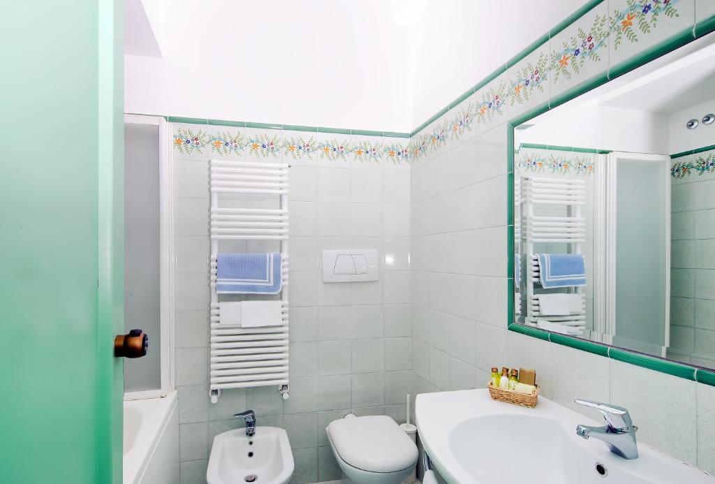 a bathroom with a sink and a toilet and a mirror at Hotel Le Terrazze in Conca dei Marini