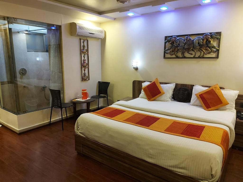 a hotel room with a bed and a shower at Shaleen Elegance Homestay Near Nakki Lake in Mount Ābu