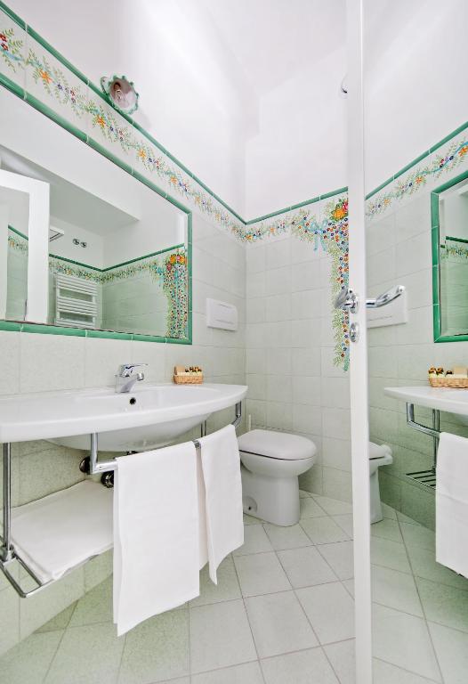 a bathroom with a sink toilet and a mirror at Hotel Le Terrazze in Conca dei Marini