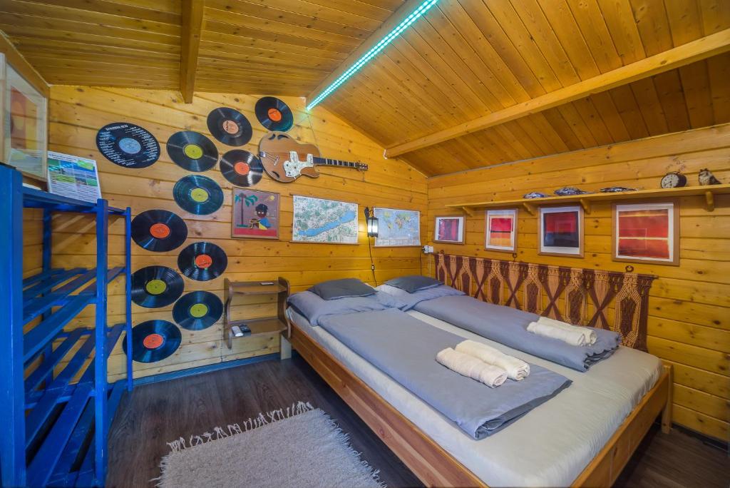 ein Schlafzimmer mit einem Bett in einer Holzhütte in der Unterkunft Páros faház in Balatonföldvár