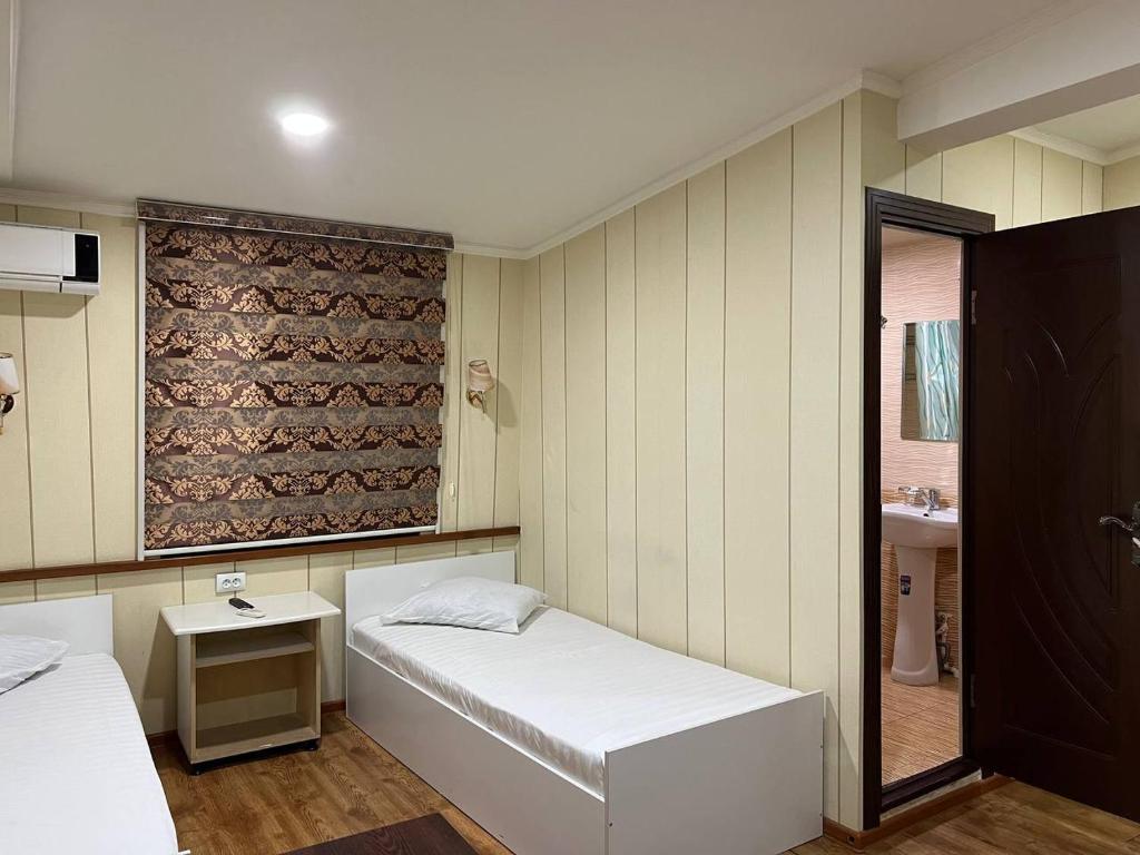 YakkasarayにあるHivaのベッド2台とシンクが備わる小さな客室です。