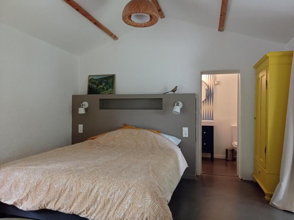 um quarto com uma cama num quarto branco em Gîte d'Espinières em Orniac