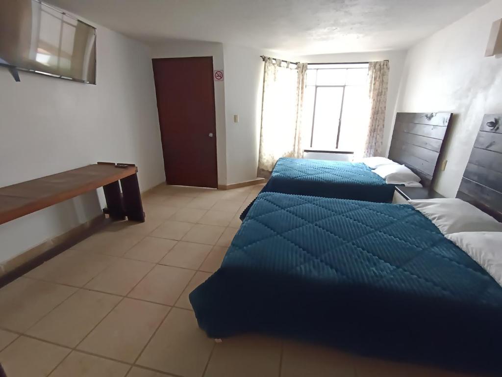 a room with two beds and a desk in it at El Arrayan in Valle de Bravo