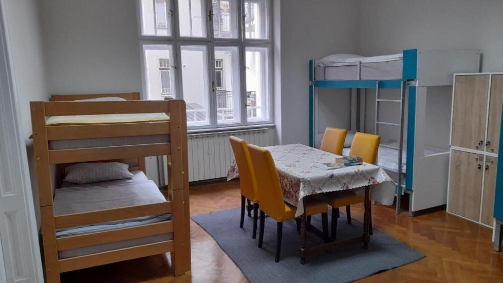 a room with a table and chairs and a bunk bed at Zeynep Apartments in Sarajevo