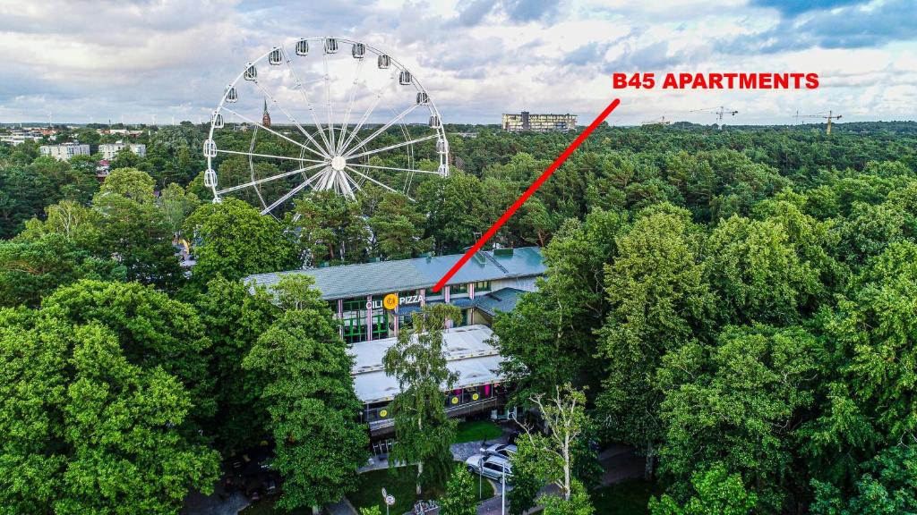 ein Riesenrad und ein Gebäude inmitten von Bäumen in der Unterkunft Basanavičiaus g. 45 Apartments in Palanga