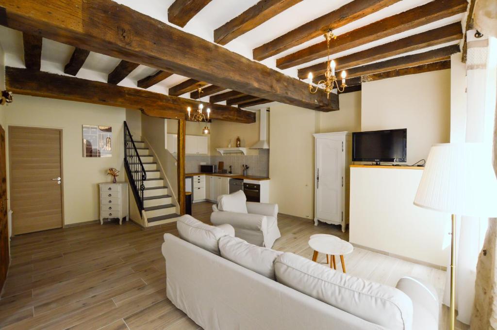 uma sala de estar com um sofá branco e uma escada em Le Logis du Beffroi em Sancerre