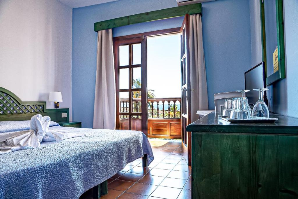 sypialnia z łóżkiem i stołem z oknem w obiekcie Hotel Jardín Concha w mieście Valle Gran Rey