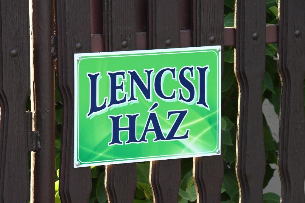 un cartel en una valla que diga la hora más grande en Lencsi ház, en Abádszalók