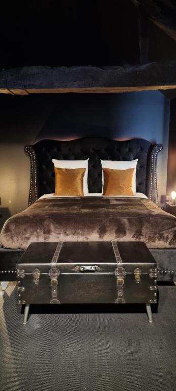 ein Schlafzimmer mit einem Bett mit Kofferraum in der Unterkunft Bayeuzen Le Jardin - Nuit Romantique et Spa Privatif Bayeux in Bayeux