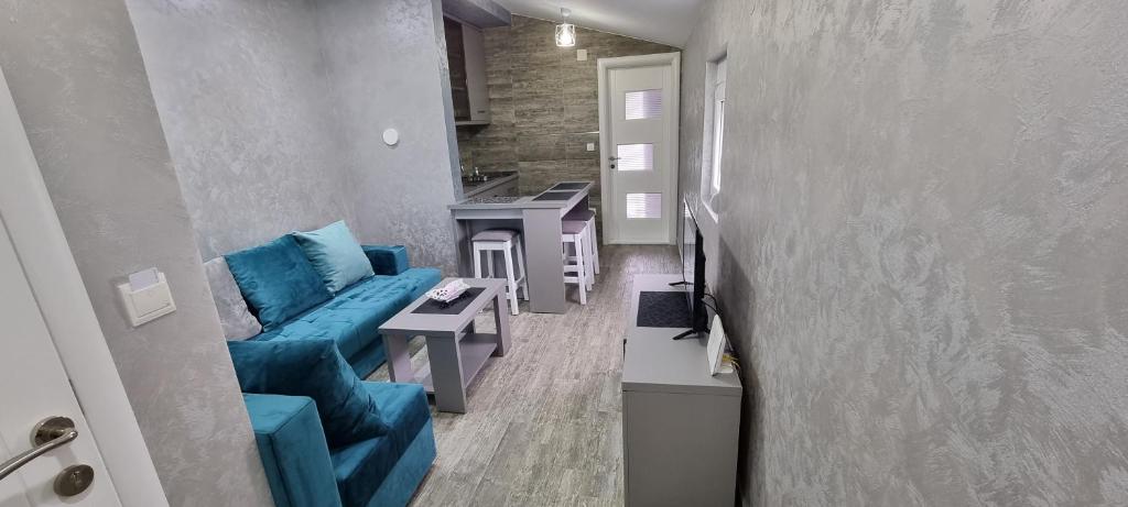 ein Wohnzimmer mit einem blauen Sofa und einer Küche in der Unterkunft Amarok in Bar