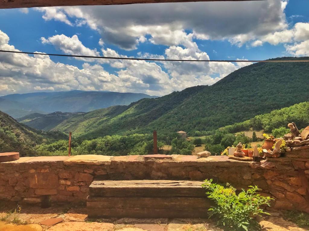 un banco de piedra con vistas a las montañas en Casa Manel - Loft rústico con encanto, en Montcortès