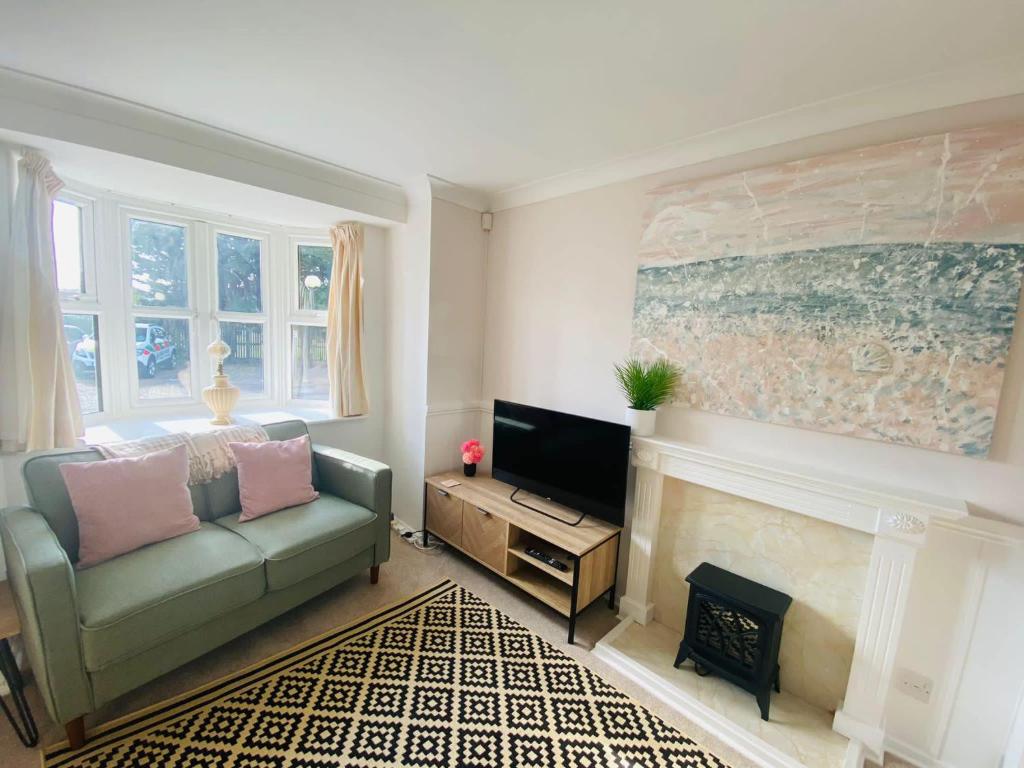 a living room with a couch and a fireplace at Coastal 2 bedroom maisonette with parking in Eastbourne