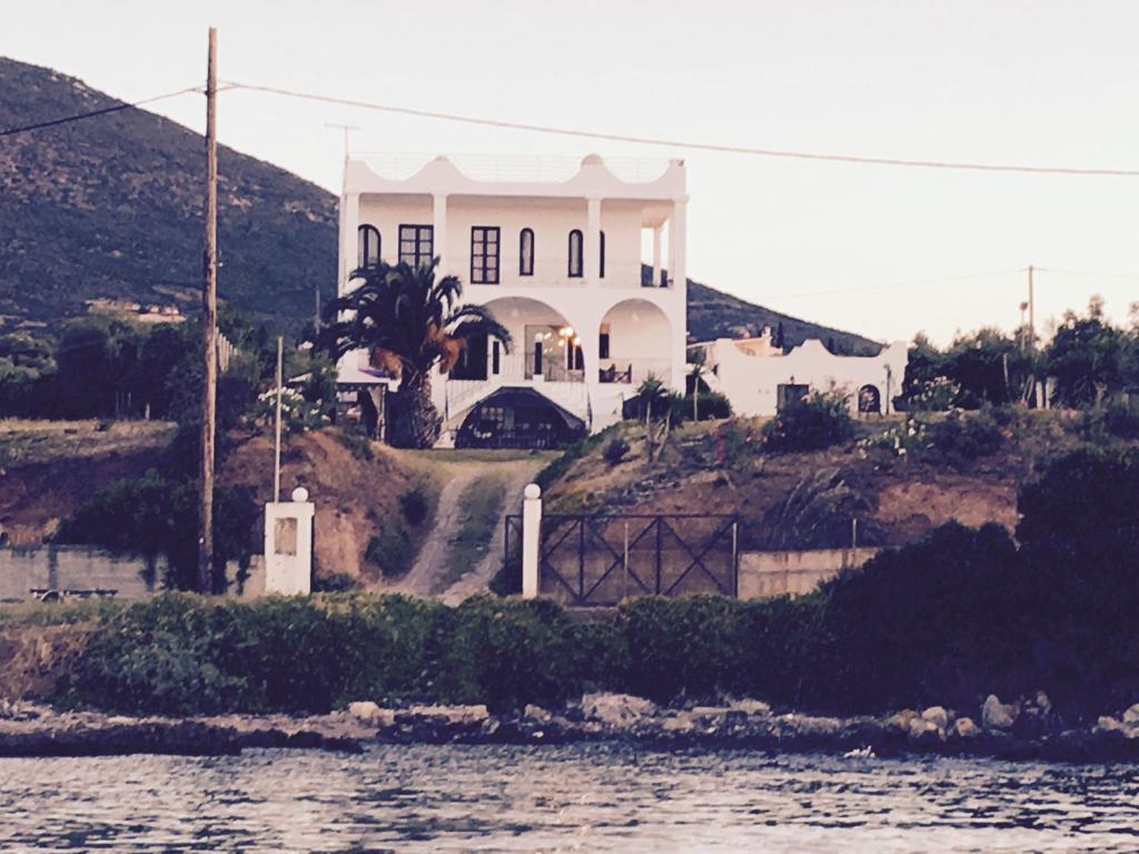 una casa blanca en una colina junto al agua en Magic house at halkida 1m from the beach! en Chalkida