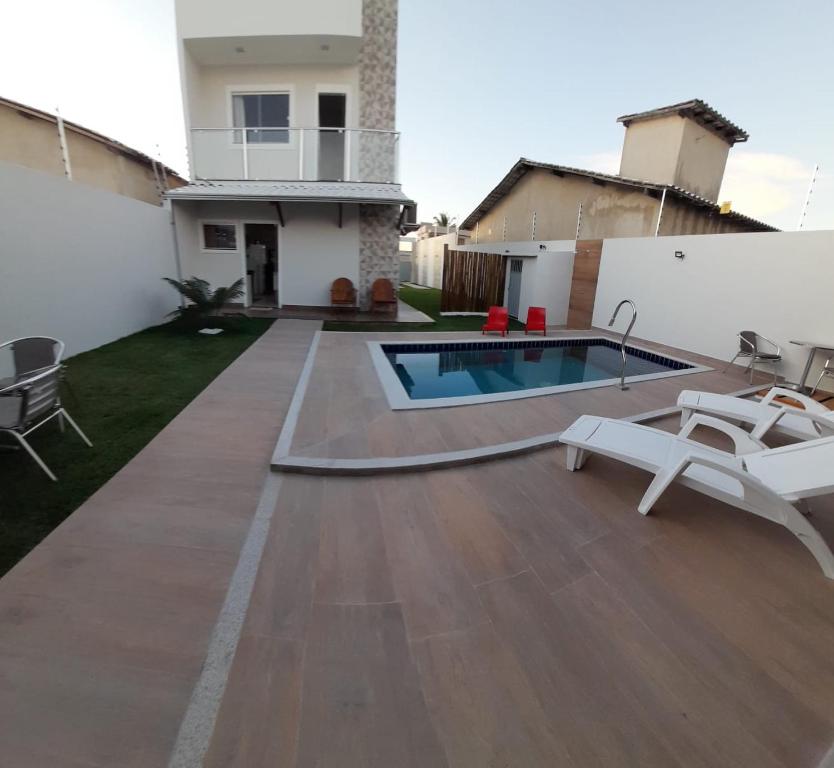 ein Hinterhof mit einem Swimmingpool und einem Haus in der Unterkunft Casa PraiAmar 20 in Prado