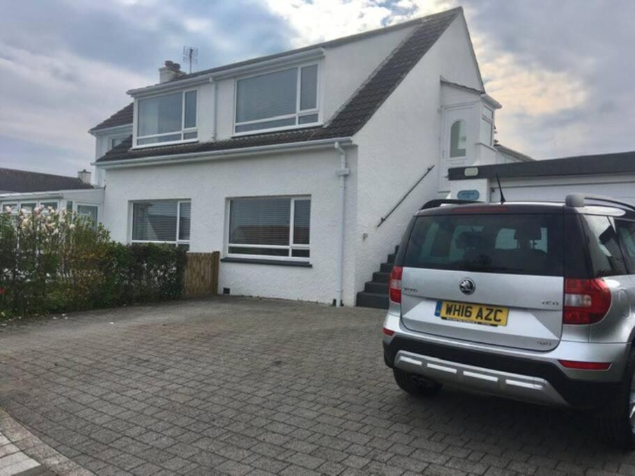 un coche aparcado frente a una casa blanca en Seymour Apartment - Looe, en Looe