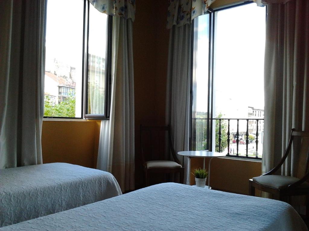 pokój hotelowy z dwoma łóżkami i oknem w obiekcie Hotel Luzon w mieście San Vicente de la Barquera
